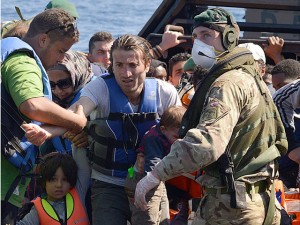 The sailors and Royal Marines of HMS Bulwark help migrants ashore. Picture by Royal Navy Media Archiv Carl Osmond